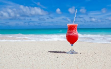 Strawberry daiquiri on white sandy beach-turquoise sea-blue sky