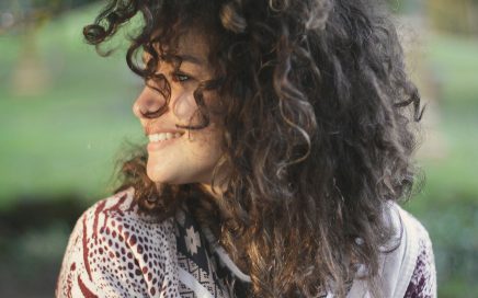 Happy young woman-smiling-long curly dark hair