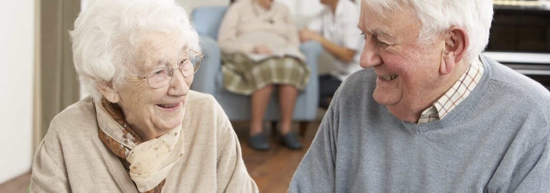 Elderly couple smiling in care home